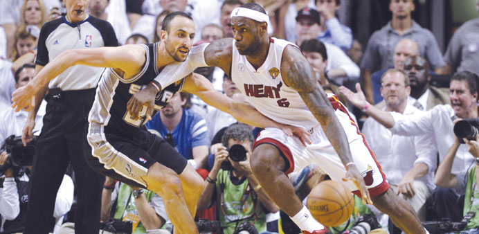 LeBron James (right) of Miami Heat drives against Manu Ginobili  of San Antonio Spurs during Game 6 of their NBA Finals clash in Miami, Florida, on Tu