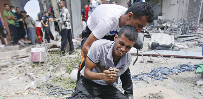 A man reacts after the body of his mother was removed from under the rubble of their house which was destroyed in an Israeli air strike in Rafah in th