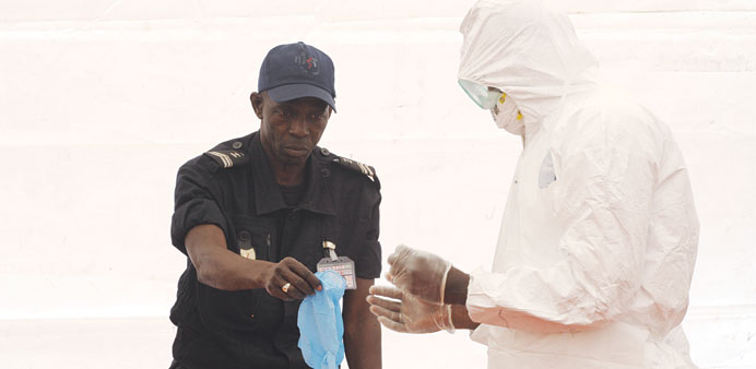 A Senegalese hygienist demonstrates how to protect oneself against the Ebola virus at Dakar airport.