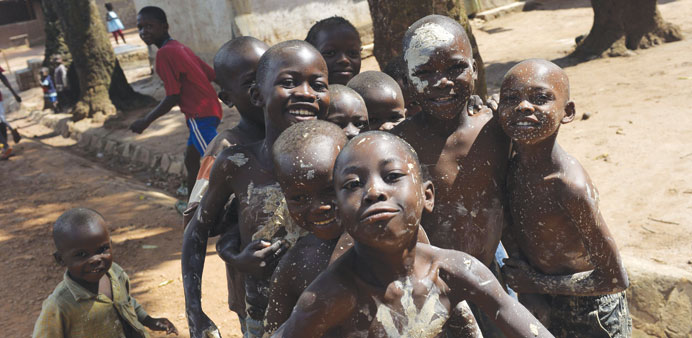 A group of boys covered in mud pose for a picture in the Yangato district during a military patrol in Bangui.