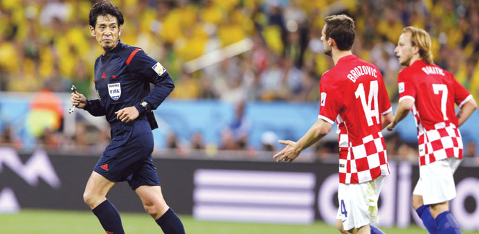 Yuichi Nishimura runs as Croatian players chase him after he awarded Brazil a controversial penalty on Thursday.