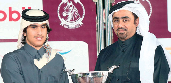 QREC chairman Sheikh Mohammed bin Faleh al-Thani (right) presents the Al Uraiq Cup to Hamad bin Mohammed bin Abdullah al-Attiya at the Qatar Racing an