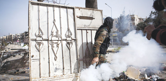 A Free Syrian Army fighter throws a homemade smoke device at the regimeu2019s soldiers during fighting in Saif Al Dawla district, Aleppo.