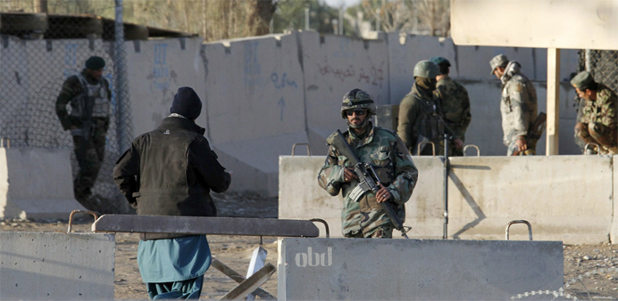 Afghan security forces stand guard at the entrance gate of Kandahar Airport 