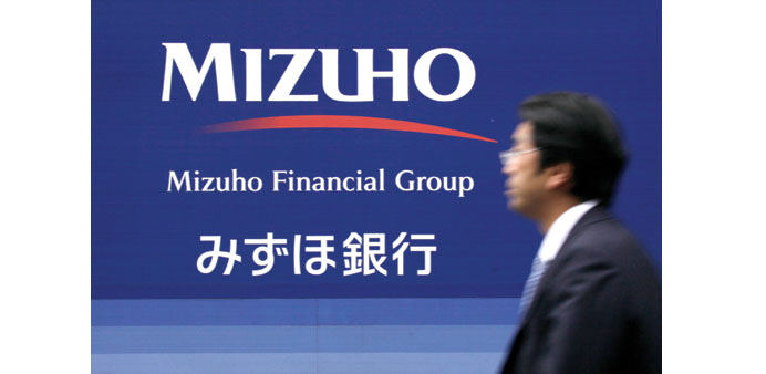 A pedestrian walks past the logo for Mizuho Bank in Tokyo. The bank is seeking to capitalise on Japan Incu2019s increasing appetite for overseas takeovers