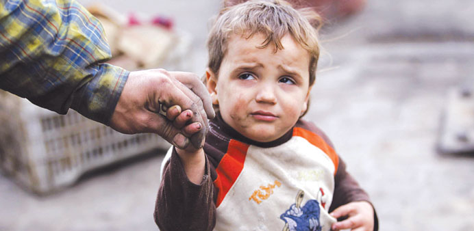 A child reacts as he holds his fatheru2019s hand after hearing what activists said was shelling by regime forces in Aleppo yesterday.