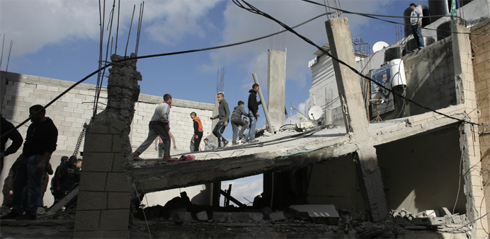 Palestinians check the house of a man who carried out a car-ramming attack last year, after it was demolished by Israeli authorities