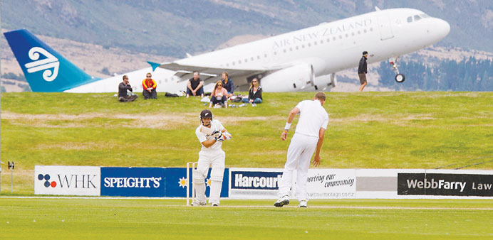 New Zealandu2019s BJ Watling (front L) bats as an Air New Zealand plane takes off on the last day of the four day warm-up against England in Queenstown on