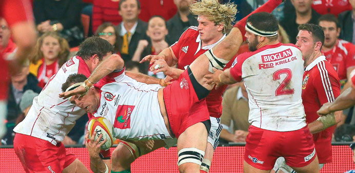 Reds player Jake Schatz (C) is tackled during the rugby union tour match between the Queensland Reds and the British and Irish Lions at Suncorp Stadiu