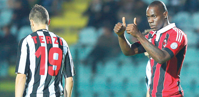 AC Milanu2019s Italian forward Mario Balotelli (R) gestures next to Sienau2019s Italian defender Claudio Terzi during their Italian Serie A match at Artemio F