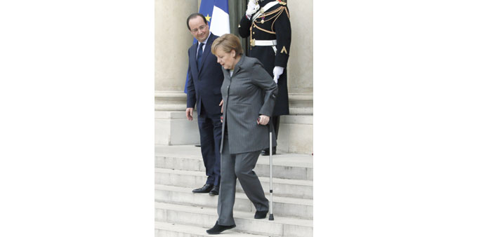 Merkel accompanied by French President Francois Hollande as she leaves the Elysee Palace yesterday.