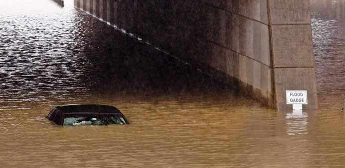 A Uber driver talks on the phone after he drove his car into high water in Houston, Texas, yesterday.