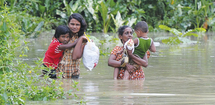 Residents wading through floodwaters in Matugama, some 64km south of Colombo, after heavy monsoon rains caused havoc in the western, southern and cent