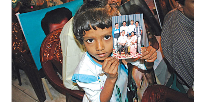 A girl holds a picture of relatives missing from Sri Lankau2019s 26-year long civil war during a meeting in Colombo.