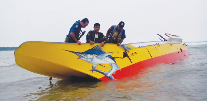 In this undated handout photo released by Philippine National Police-Jolo (PNP) yesterday, policemen inspect a boat allegedly used by the kidnappers o