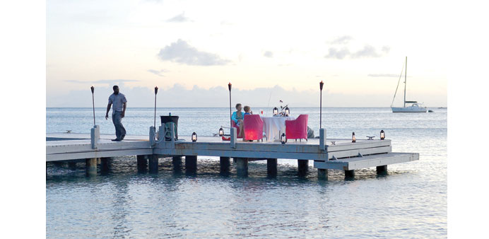 EXPERIENCE: Visitors dine on the jetty at sunset at Carlisle Bay resort in Antigua.
