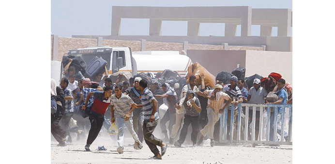 Egyptians try to force their way at the border crossing of Ras Jdir, southeast of Tunis, yesterday.