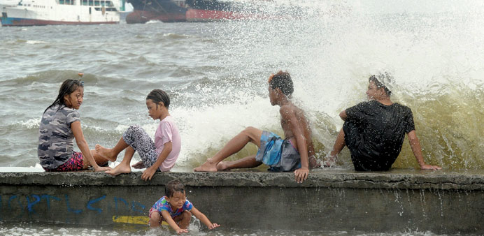 Residents along Manila Bay play in the waves created by nearby Typhoon Noul as it approaches the northern Philippines yesterday.