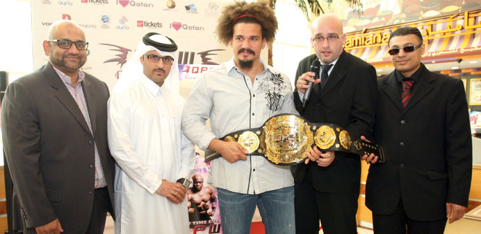 Carlito (middle), flanked by the organisers, with the title belt yesterday.
