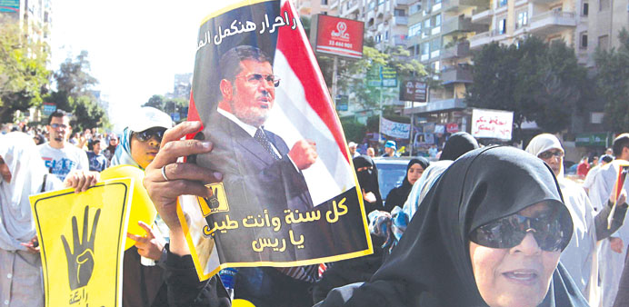 A Mursi supporter holds a poster of him during the protest in Cairo yesterday.