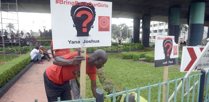 Campaigners mount a sign post with the names of each of the 276 abducted Chibok schoolgirls to press for their release during a rally to mark 100 days