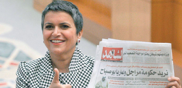 MP Safa al-Hashem holds a newspaper bearing a headline calling for a capable government at the National Assembly in Kuwait City yesterday.