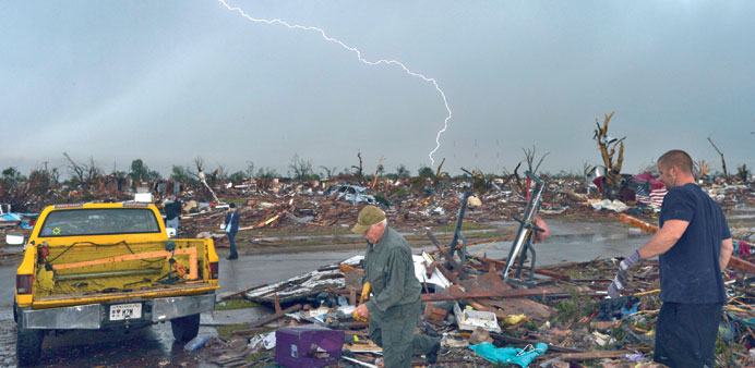 Lightning strikes during a thunderstorm yesterday as tornado survivors try to salvage what they can at their devastated home in Moore, Oklahoma.