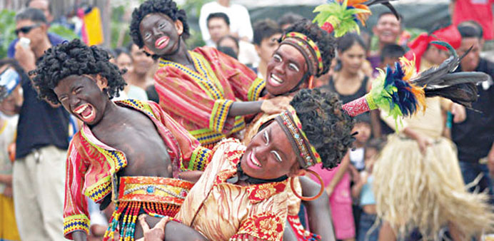 File photo shows performers in colourful costumes dancing along the streets of Baseco compound in Manila as they take part in an Ati-Atihan parade con