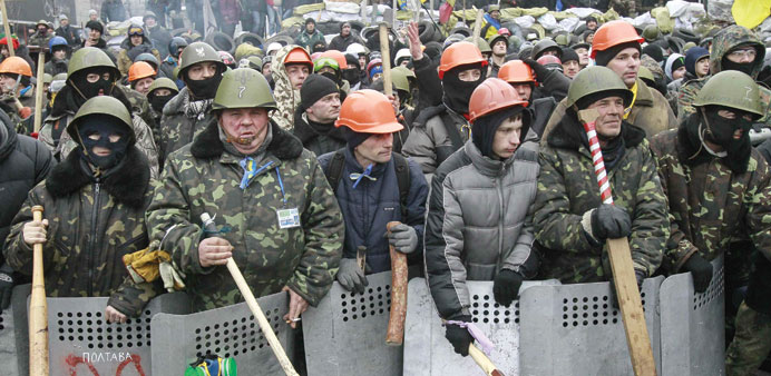 Anti-government protesters stand guard at their barricades in Kiev.