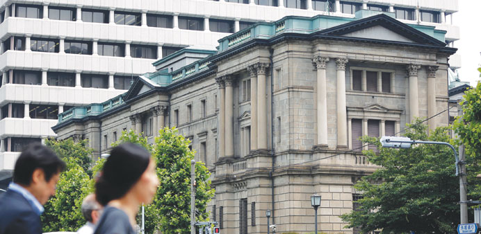 Pedestrians walk past the Bank of Japan headquarters in Tokyo (file). The BoJ is expected to keep monetary policy on hold at a review this week.