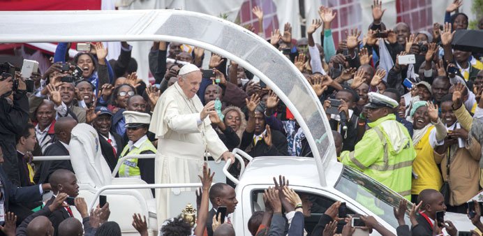 Pope Francis waves to the crowd at the University of Nairobi as he arrived to deliver an open-air mass.