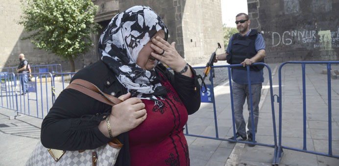 A woman cries as she walks past a Turkish police officer blocking a street in central Diyarbakir yesterday.