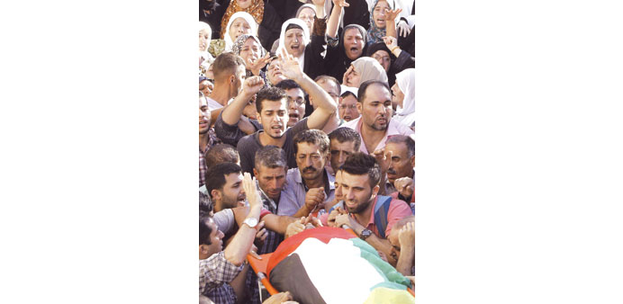 Mourners carry the body of Tamer Smour during his funeral yesterday in Deir al-Ghoson near Tulkarem.