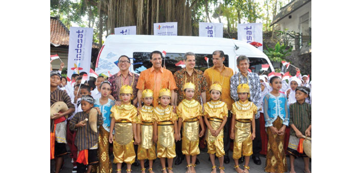Parents and children along with Ooredoo officials at the launch of a mobile health clinic.
