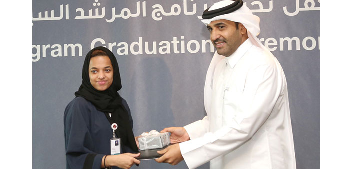 A graduate receiving a certificate from al-Mohannadi.