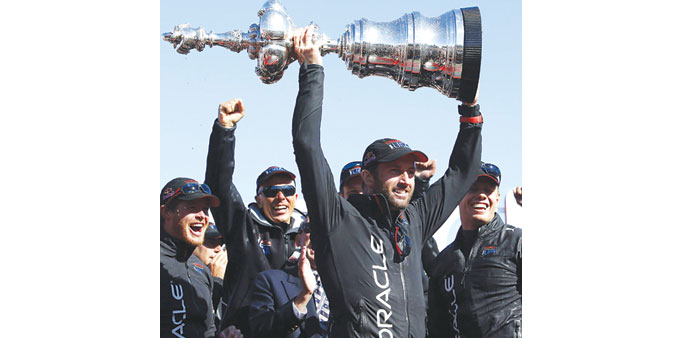 Oracle Team USA tactician Ben Ainslie holds up the Americau2019s Cup trophy on Wednesday. (EPA)