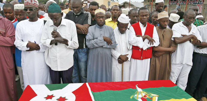 Men pray in front of the coffin of Zedi Feruzi, the head of opposition party UPD, during his funeral in Bujumbura yesterday.