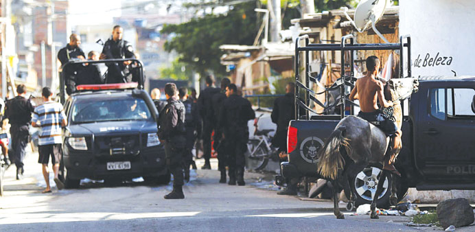 Policemen patrol during an operation at the Mare slums complex in Rio de Janeiro yesterday.