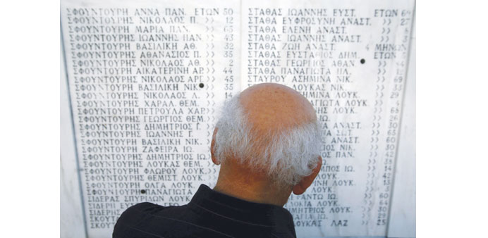 A survivor looks at the names of those killed by Nazis during ceremonies in a mausoleum in the village of Distomo northwest of Athens in this June 9, 