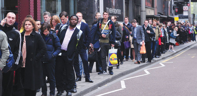 Commuters form long queues for buses outside Waterloo Station in London yesterday.