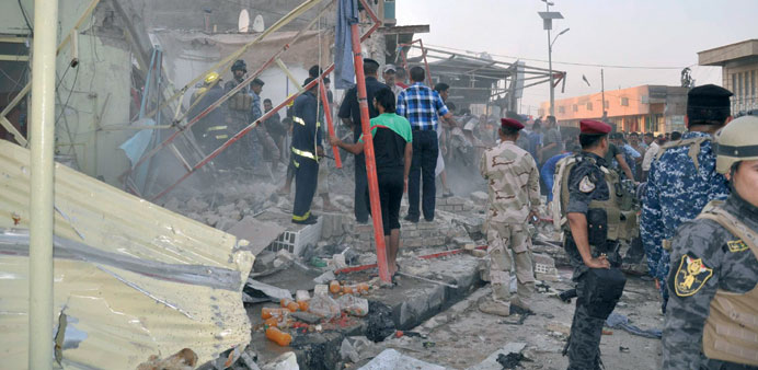 Iraqi security forces and residents gather at the site of the blast in Kut yesterday.