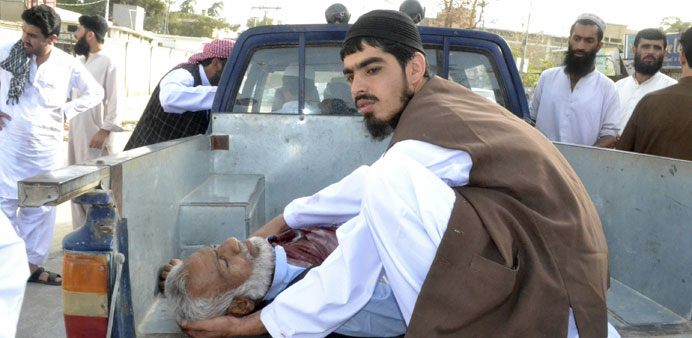 An injured man is transported on a van to the hospital after gunmen fired on the vehicle of a politician driving past worshippers near a mosque, killi
