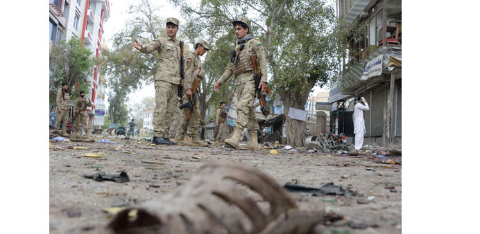Afghan security personnel look on at the scene of a suicide attack outside a bank in Jalalabad yesterday.