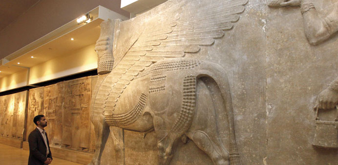 An Iraqi officials looks at ancient Assyrian human-headed winged bull statues at the Iraqi National Museum in Baghdad.