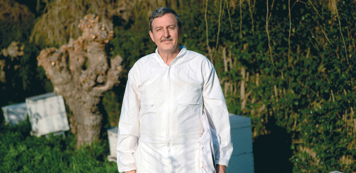  Professor Paschalis Harizanis poses in front of his beehives at the Agricultural University of Athens.