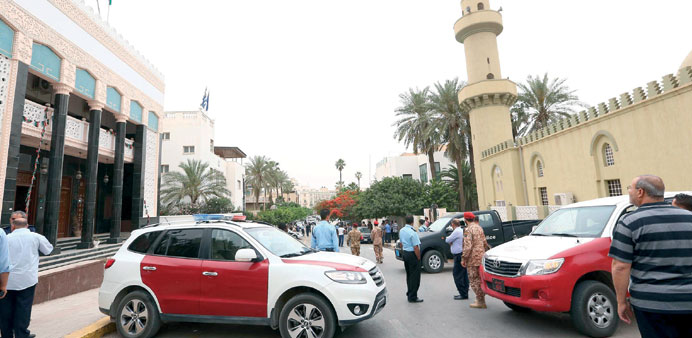 Security personnel and residents gather in the street where the bomb exploded in Tripoli yesterday.