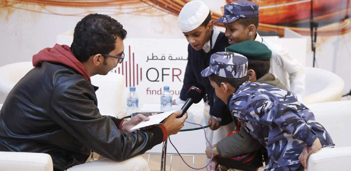 Young boys send a message to Qatar on National Day at the QF Radio booth at Darb Al Saai tent.