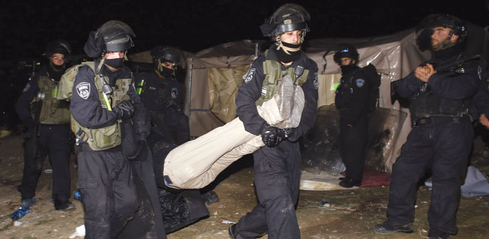Israeli border police remove a Palestinian from the protest camp in the E1 area of the West Bank yesterday.