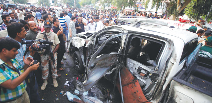 Security personnel and media members are seen at the site of suspected suicide bomb attack in Karachi in this July 10, 2013 file photo.