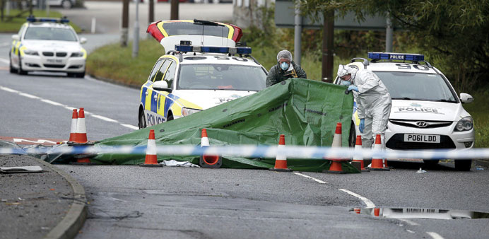 Police forensic officers work at Wallasey Dock Road where police officer Phillips (inset) was struck and killed by a car in Wallasey, Britain, yesterd